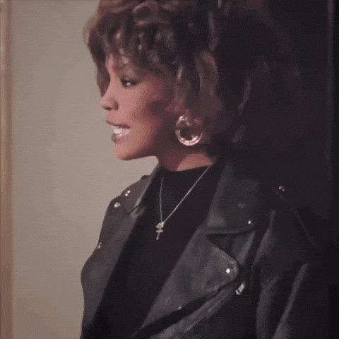 a woman wearing a leather jacket has a cross necklace around her neck