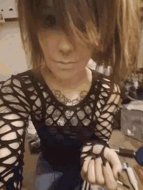a woman with a tattoo on her chest is wearing a black shirt