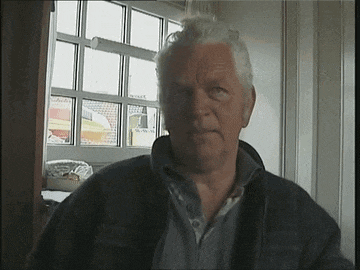 a man with gray hair is looking at the camera