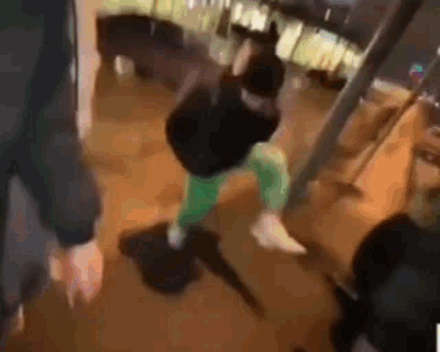 a blurry picture of a person holding a gun while standing on the floor .