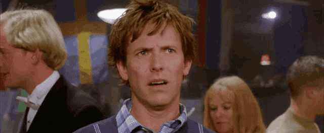 a man with a surprised look on his face is in a crowd of people