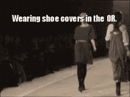 a woman wearing shoe covers is walking down the runway