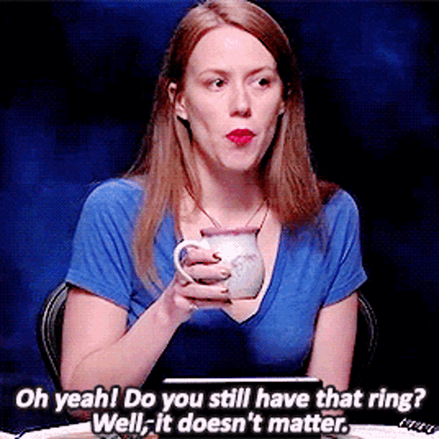a woman in a blue shirt is holding a mug and says oh yeah