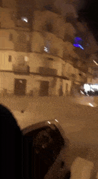 a car is driving down a street at night