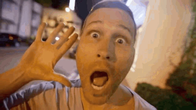 a man with a surprised look on his face holds his hand to his ear