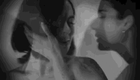 a black and white photo of a man and woman kissing each other .