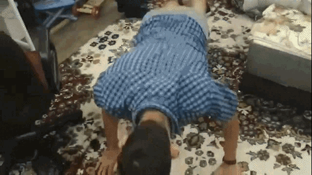 a man is doing push ups on a rug in a room .