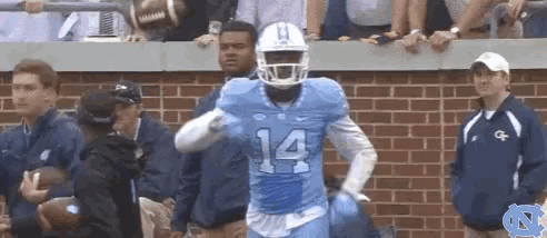 a football player with the number 14 on his jersey is running