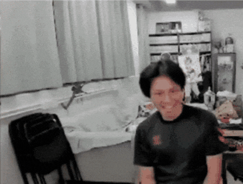 a man wearing a black shirt with the letter s on it is smiling