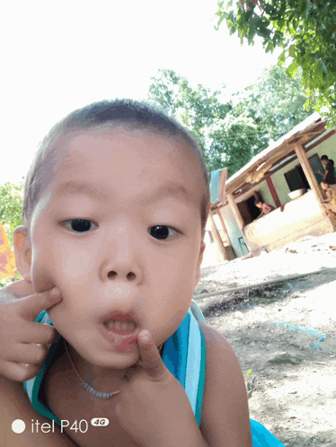 a little boy is being held by someone and the phone says itel p40 4g on the bottom