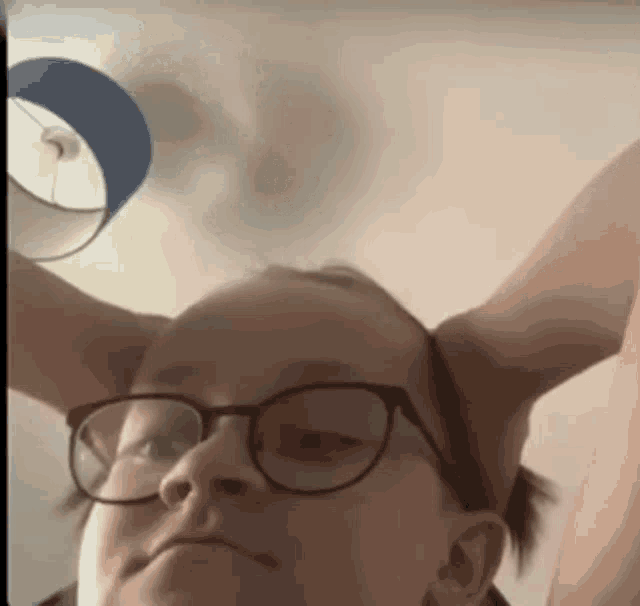 a close up of a person wearing glasses making a funny face