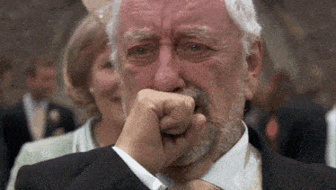 a man with a beard is covering his mouth with his hand