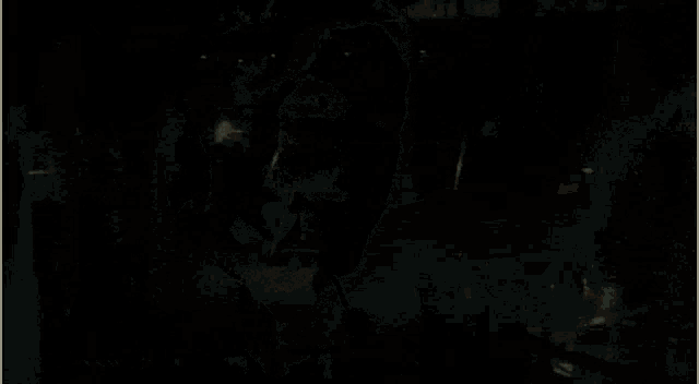 a man is standing in a dark room with a smoke coming out of his mouth .