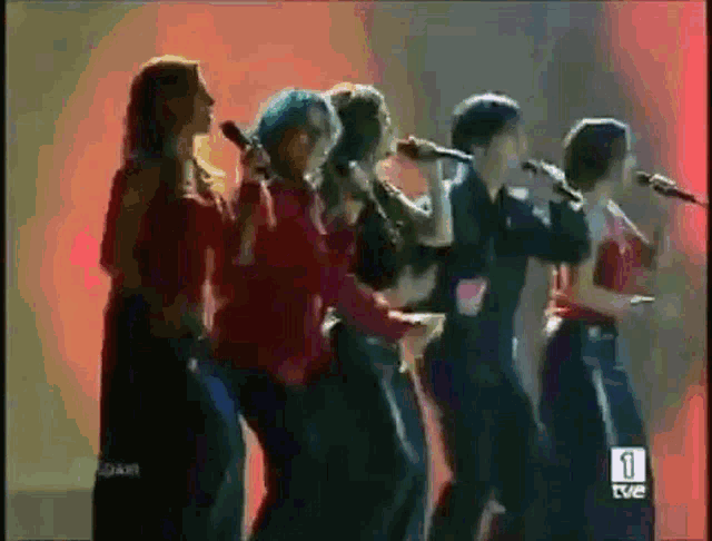a group of people singing into microphones with the number 1 on the bottom