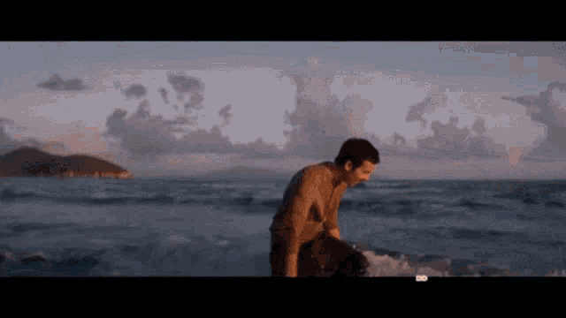 a man is standing on a beach near the ocean .