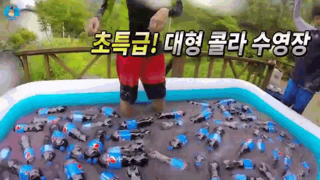 a person is standing in a pool filled with bottles of pepsi