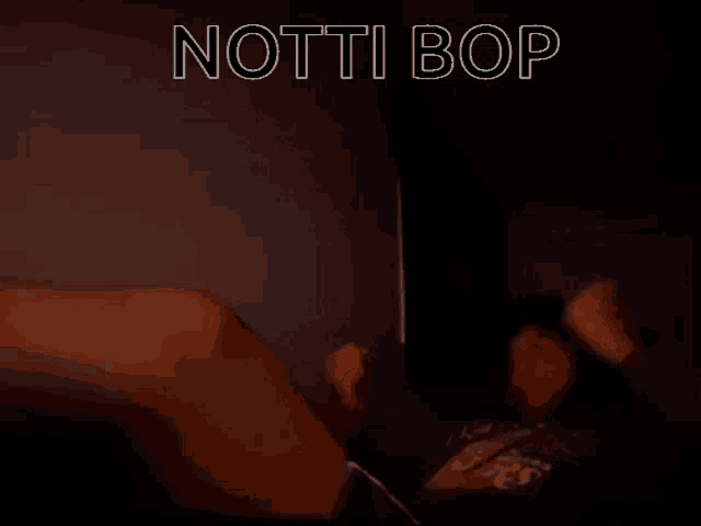 a person laying on a bed with the words " notti bop " in white letters