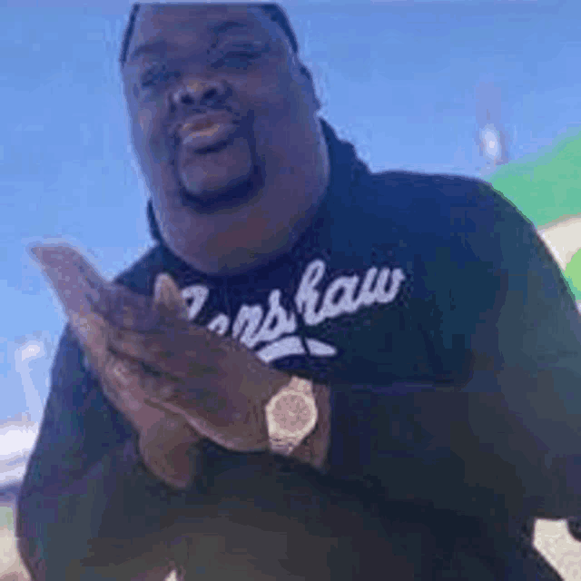 a man wearing a black shirt is clapping his hands .