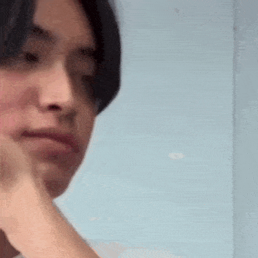 a close up of a person 's face with their hand on their chin .