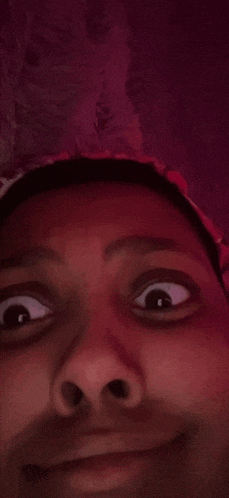 a close up of a person 's face with a purple background .
