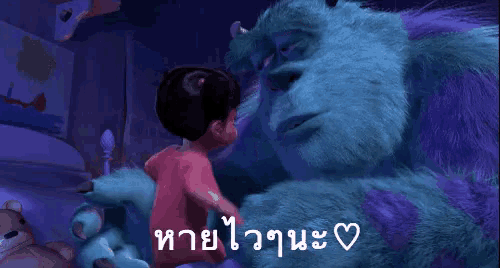 a boy is hugging a stuffed monster from monsters inc .