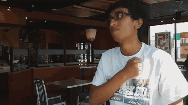 a man wearing glasses and a white shirt that says ' the 2 ' on it
