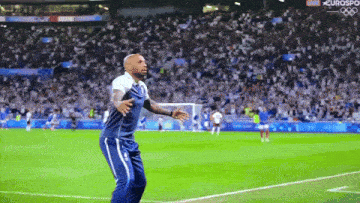 a man stands on a soccer field in front of a crowd with eurosport on the bottom right