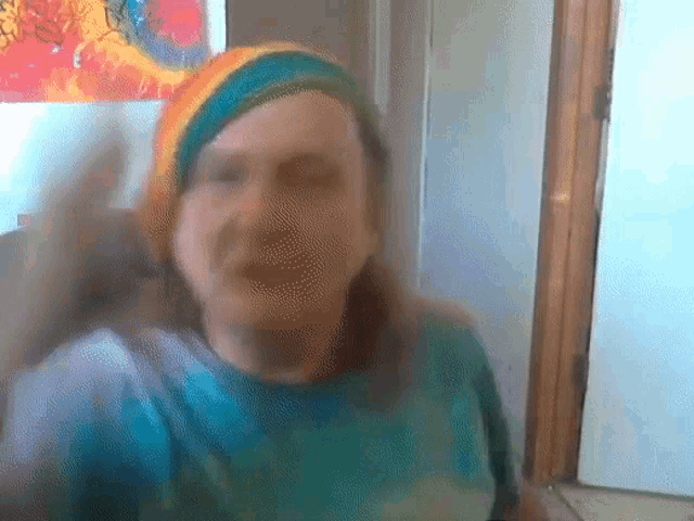 a person wearing a tie dye shirt and a rainbow hat