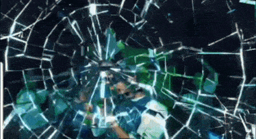 a man is standing in front of a broken glass window with a green background .