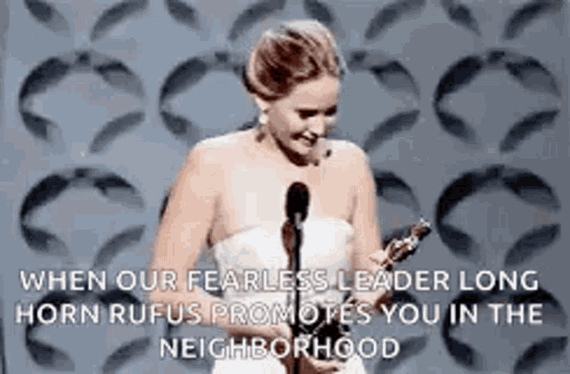 a woman in a white dress is standing in front of a microphone .