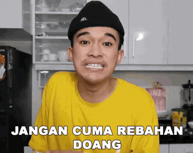 a man wearing a yellow shirt and a black hat with the words jangan cuma rebahan doang below him