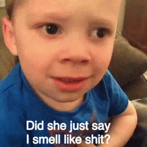 a young boy is sitting on a couch and says did she just say i smell like shit .