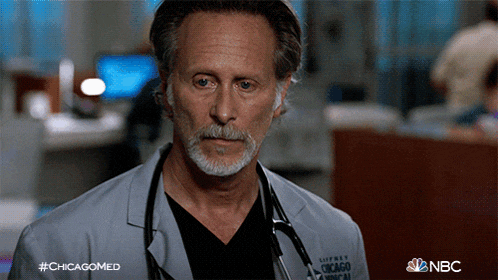 a man with a beard and a stethoscope around his neck is wearing a white coat from nbc
