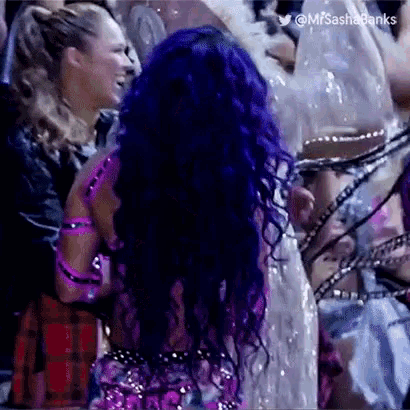 a woman with purple hair and a purple dress is standing in a crowd .