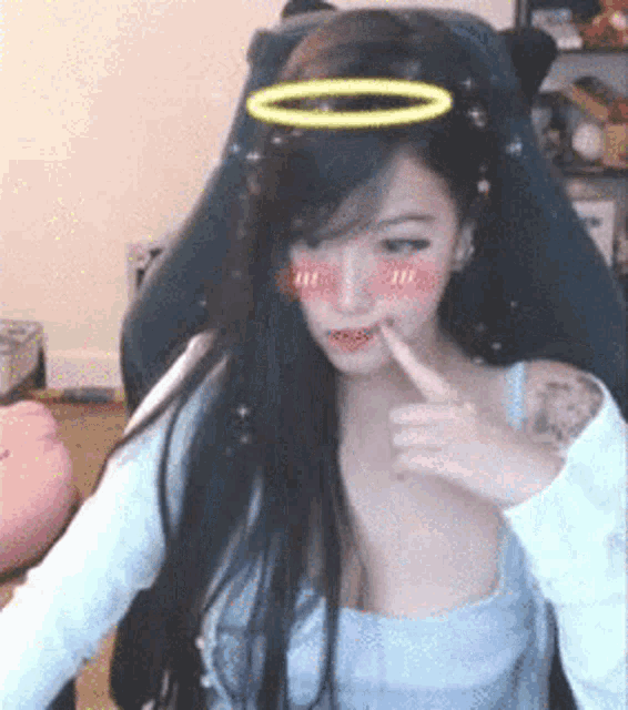 a woman with long hair and a halo on her head is sitting in a gaming chair .