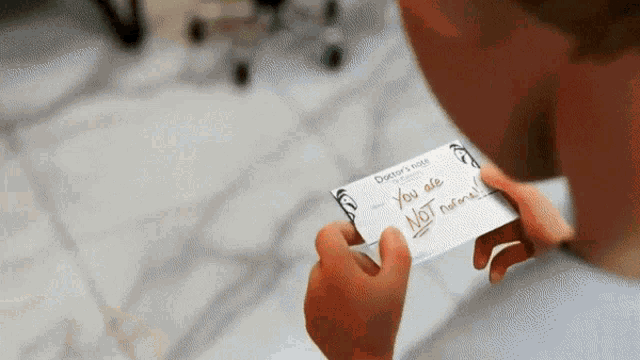 a person holding a piece of paper that says you are not a fan