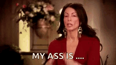 a woman in a red dress is sitting in a chair and saying `` my ass is '' .