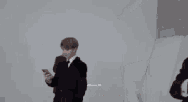 a man in a suit is taking a picture of himself on his phone