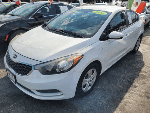 a white kia car is for sale with a yellow tag