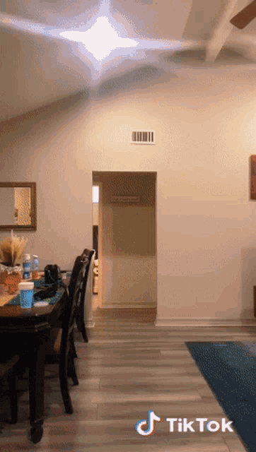 a living room with a table and chairs and a tiktok logo on the bottom