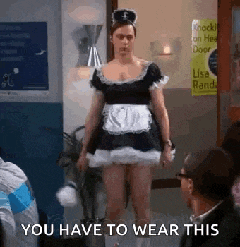 a man in a maid costume is standing in a room with people .