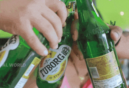 a bottle of tuborg strong beer is being poured into a glass