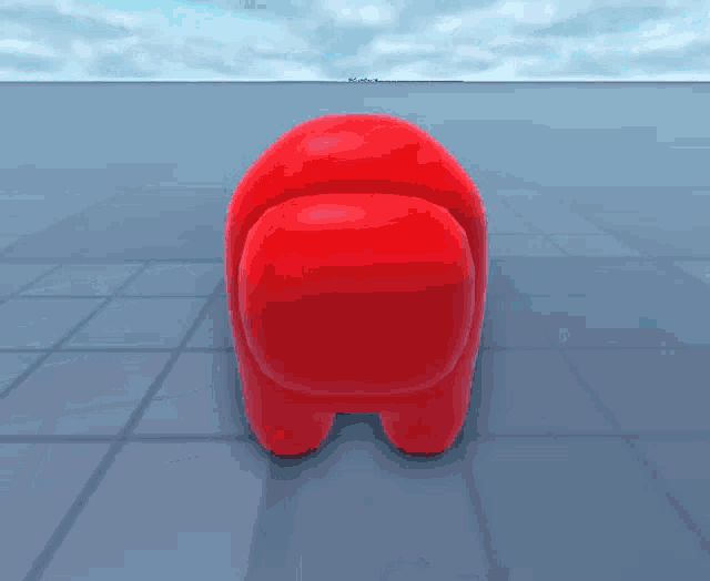 a red among us character is laying down on the ground