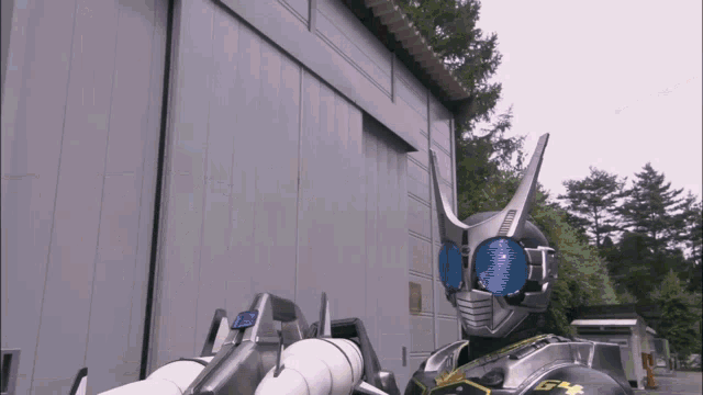 a man in a robot costume is standing in front of a large building