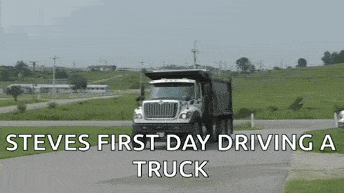 a dump truck is driving down a road with the words `` steve 's first day driving a truck '' below it .