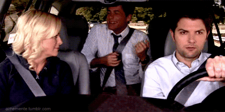 a man in a tie is talking to a woman in the back seat of a car while another man adjusts his tie