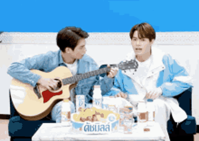 a man is playing a guitar next to another man who is playing a guitar