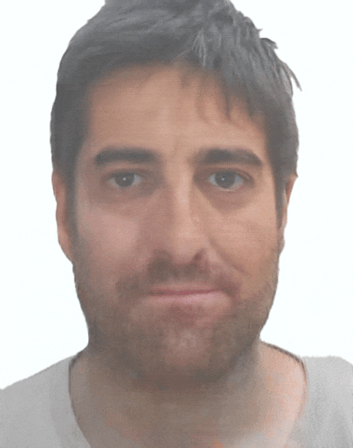 a man with a beard wearing a white shirt looks at the camera