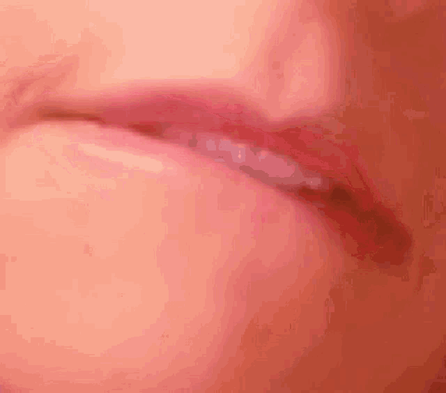a close up of a person 's lips with a pink lipstick .