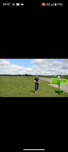 a green and white vehicle is parked on a runway .